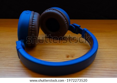 Modern blue headphones on a wooden table