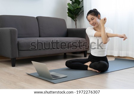 Asian women exercise at home with online video tutorials on the internet. Healthy exercise ideas