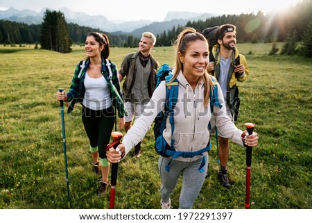 Group of fit healthy friends trekking in the mountains Royalty-Free Stock Photo #1972291397