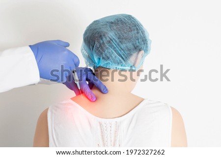 The doctor makes an injection medical blockade into the paravertebral tissue to relieve pain and pinch the neuronal root. Modern method of treatment in neurology, types of injection blockades, trigger Royalty-Free Stock Photo #1972327262