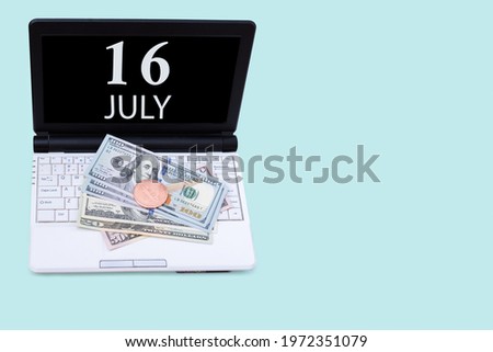 16th day of july. Laptop with the date of 16 july and cryptocurrency Bitcoin, dollars on a blue background. Buy or sell cryptocurrency. Stock market concept. Summer month, day of the year concept.