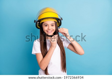 Portrait of attractive cheerful girl wearing fixing protective helmet casque isolated over vivid blue color background