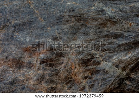 A texture picture of a rock. Dark in colour. 