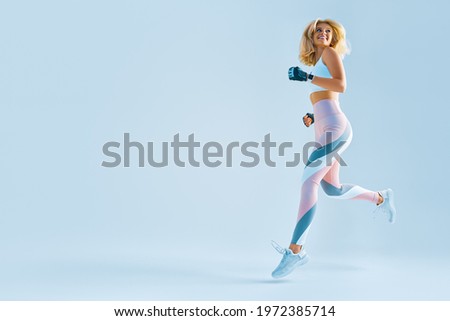 Sportswoman feeling happy. Caucasian female in sportswear running. Motivation fitness concept photo with copy space Royalty-Free Stock Photo #1972385714