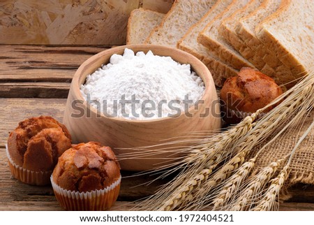 All purpose wheat flour in bowl on wooden background Royalty-Free Stock Photo #1972404521
