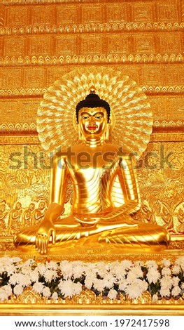 Golden Buddha statue surrounded by flowers.