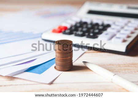 on a wooden table calculator, coins and statistics