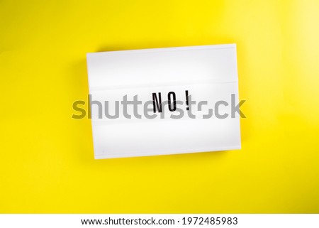 Lightbox with text NO isolated on yellow background. Concept of negative expression, renouncement, warning, instruction, prohibition, danger, ban, stop, embargo, taboo, forbiddance, protest, surrender