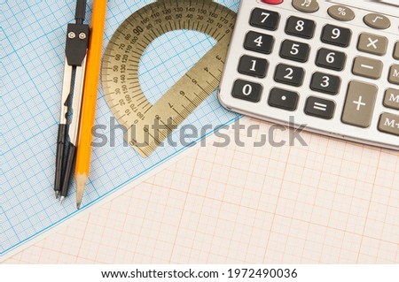 Mathematical instruments lie on a graph paper with copy space for text. Math graphic tools concept.