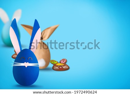 Traditional Easter symbols concept. Cute rabbits from eggs on a desk