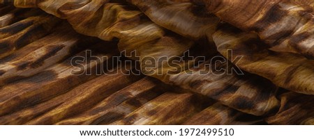 Silk fabric made of fine organza with print imitating panther skin, brown. Texture. Background. Template.