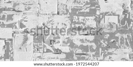 Grunge Wide Background with Old Torn Posters. Urban Graffiti Wall Texture. Grungy Ripped Wall with Torn Posters and Ads Background. Panoramic Urban Wallpaper. Graffiti Wall Texture. Royalty-Free Stock Photo #1972544207