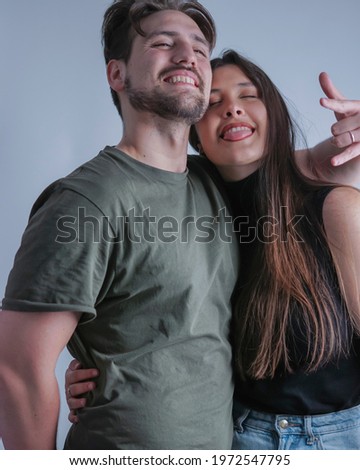 young couple of man and woman in love and fun on a plain white background