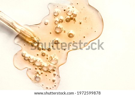 Yellow texture of a drop of whey or olive oil on a white background. Transparent sample of cosmetic gel with bubbles. Golden acid cream. Vitamin c. A drop of honey. Hyaluronic acid. Royalty-Free Stock Photo #1972599878