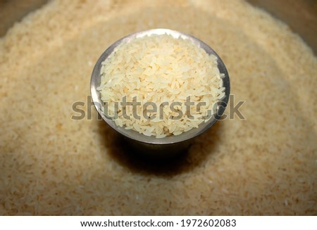 Ponni rice (An indian white rice) placed in a steel cup, surrounded by the same rice