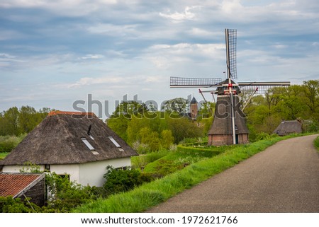 Old windmill and tower of Waardenburg castle in the dutch Province of Gelderland