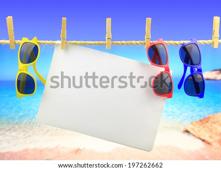 Sunglasses and banner hanging on a rope in front of the sea