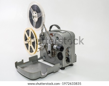 Old vintage film projector for watching films on film strip on a white background.