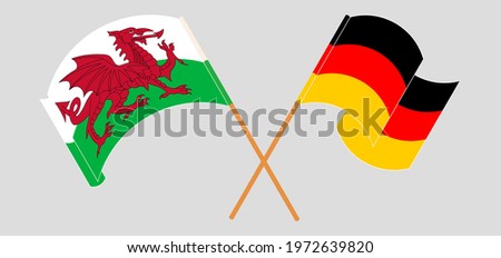 Crossed and waving flags of Wales and Germany