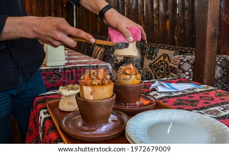 National Turkish dish cooked in a clay pot over fire that is broken before being consumed called Testi kebab. Royalty-Free Stock Photo #1972679009