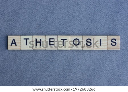 text the word athetosis from brown wooden small letters with black font on an gray table
