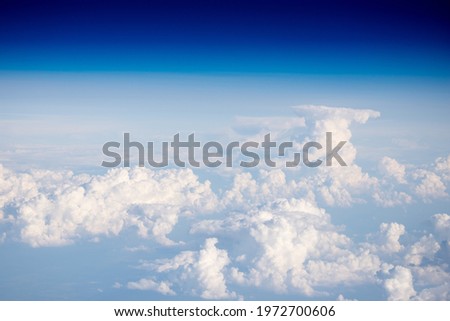Clouds from a height of ten kilometers. Sea of clouds from the plane window. Blue sky and white clouds. The Heavenly World of White Silence