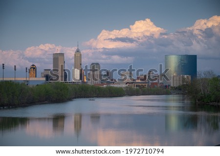 Clouds and the Indianapolis skyline are reflected in the White River