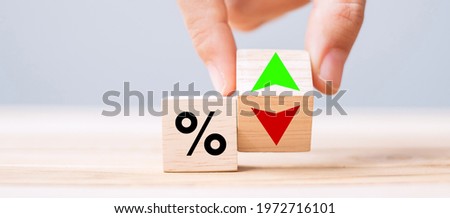 business man Hand change wood cube block with percentage to UP and Down arrow symbol icon. Interest rate, stocks, financial, ranking, mortgage rates and Cut loss concept Royalty-Free Stock Photo #1972716101