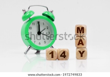 Business and holidays concept. On a white background there is an alarm clock and a calendar with the inscription - MAY 14