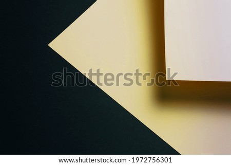 A gold and black flat lay background with sharp layers and shadows with copy space