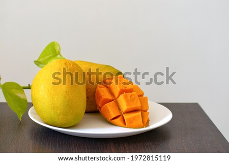 A picture of Alphonso mangoes diced in a plate on a hot sunny day. Focus is on the diced mango.