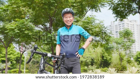 asian old man wearing helmet and carrying a bicycle - Smiling at you