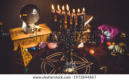  A fortune teller, witch stuff on a table, candles and fortune-telling objects. The concept of divination, astrology and esotericism Royalty-Free Stock Photo #1972844867