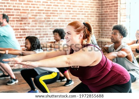 People doing squats in fitness class Royalty-Free Stock Photo #1972855688