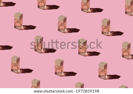 Fragnance parfume pattern. Miniature bottles of pink woman perfume on a pastel pink background, top view. Mockup of fragrance perfume. Trendy sunlight minimal concept. Royalty-Free Stock Photo #1972859198