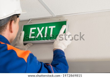 the hands of the foreman install emergency exit lighting