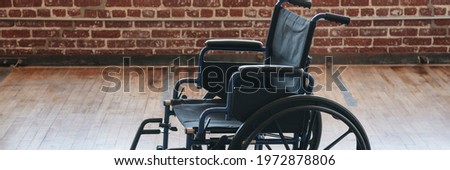 Empty wheelchair on a wooden floor