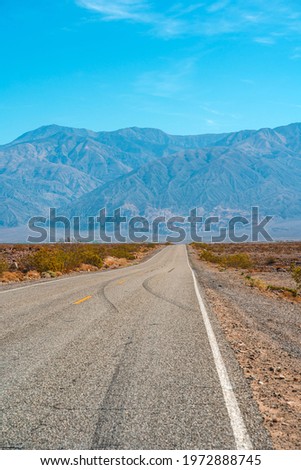 Desert scenic road in Death Valley with mountain backdrop, California, USA. Amazing natural panorama 