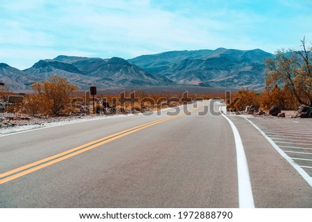 Desert scenic road in Death Valley with mountain backdrop, California, USA. Amazing natural panorama 
