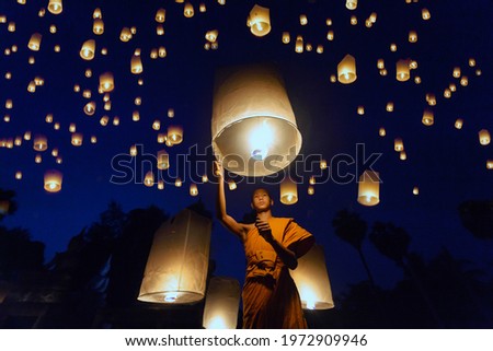 Little monks lit a fire of floating lantern,Thai Buddhist Monks float lanterns