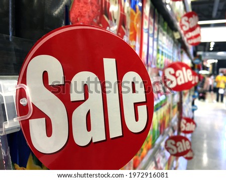 Discount sign product tags in supermarket shopping in the background.