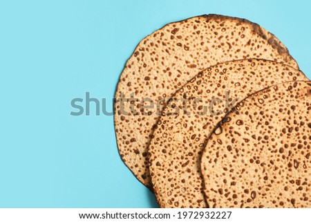 Tasty matzos on light blue background, flat lay with space for text. Passover (Pesach) celebration