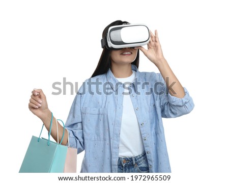 Woman with shopping bags using virtual reality headset on white background