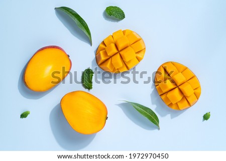 Mango design concept. Top view of diced fresh mango fruit pattern on blue table background. Royalty-Free Stock Photo #1972970450