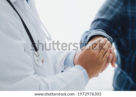 Male doctor's hands holding male patient's hand for encouragement and empathy.  reassuring and support. Patient cheering and support
