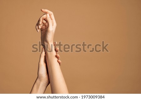 Close up of woman hands isolated on cream brown background with copy space. Smooth female hands applying moisturizer. Beauty gesturing woman's hands with care. Royalty-Free Stock Photo #1973009384