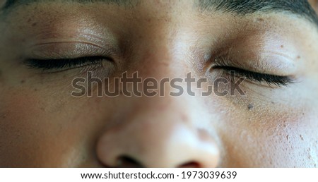 Black person closing eyes in meditation. African woman opening eye smiling