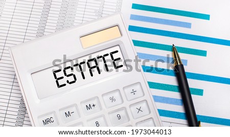 Against the background of reports and blue graphs, a pen and a white calculator with a test on the ESTATE screen. Business concept