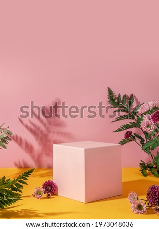 Summer style of showcase for cosmetics product display on yellow and pink background with flowers. Pink cube platform with flowers. Royalty-Free Stock Photo #1973048036