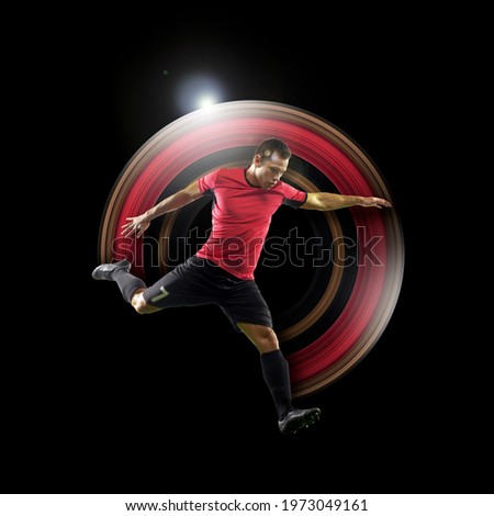 Young football, soccer player in neon light on black background. Concept of motion and action in sport. Training in jump, flight. Sport, healthy lifestyle, movement, advertising. Abstract design.